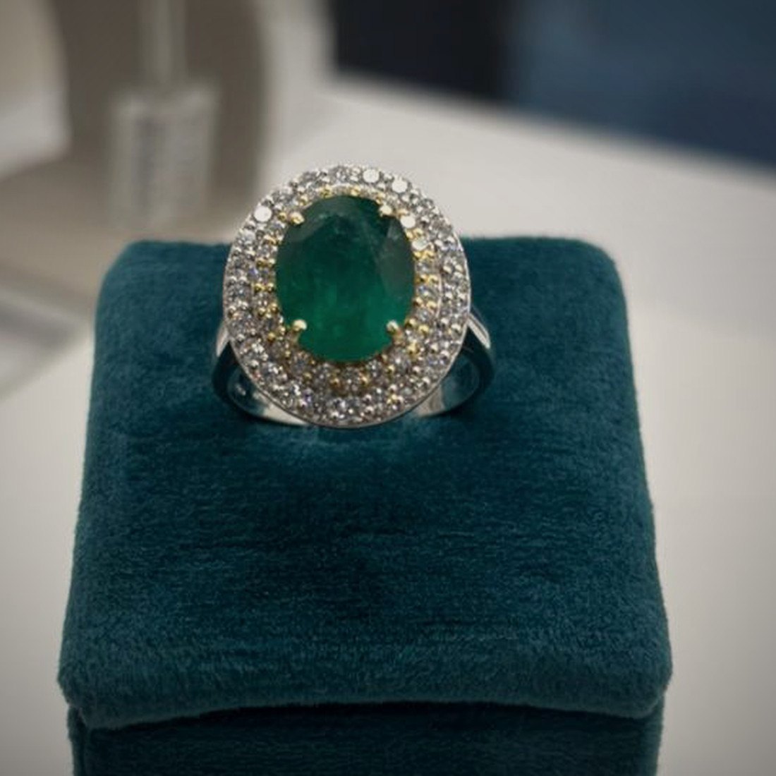 L'anello finito, con lo smeraldo montato e il contorno di diamanti
